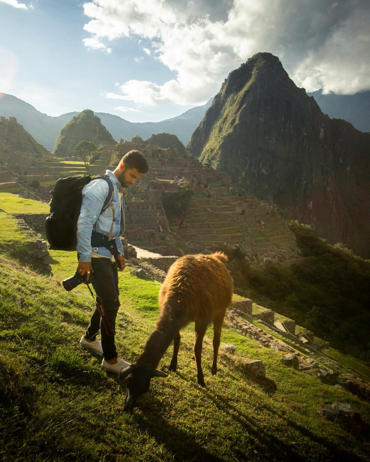 Man exploring Machu Picchu with a llama on a sunny day, capturing the essence of adventure travel.